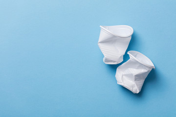 Single use white plastic cups on a blue background