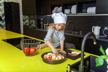 Little girl with chef hat preparing bake homemade holiday apple pie in kitchen. Kid cooking healthy...
