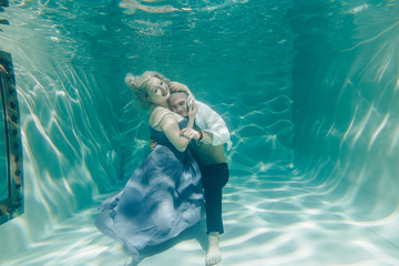 beautiful romantic couple of lovers hugging gently under water