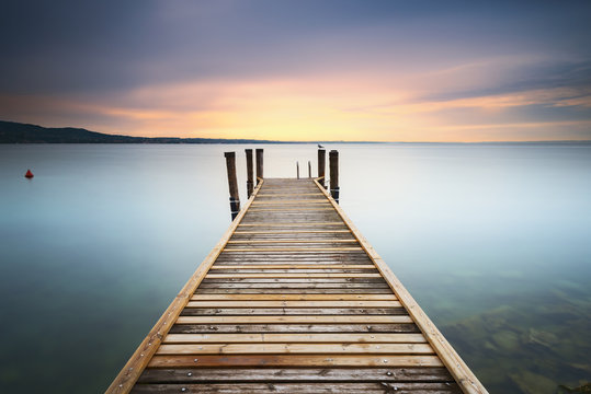 Fototapeta View of wooden pier in lake during sunset