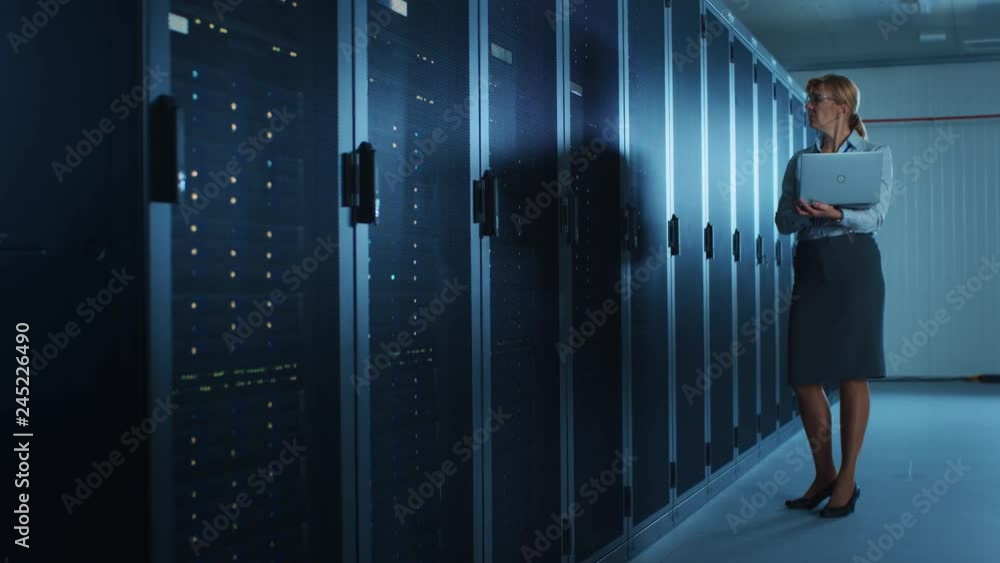 Poster in data center: portrait of professional female it specialist using laptop, doing maintenance and di