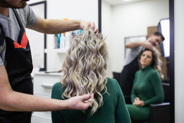 Beautiful hairstyle of mature woman after dying hair and making highlights in hair salon.