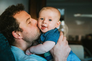 Father kissing his son at home