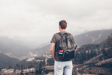 Tourist man in mountains in the background of fog © travnikovstudio