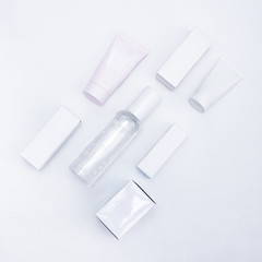 flat lay composition with white bottles and boxes from under the cosmetics on a white background