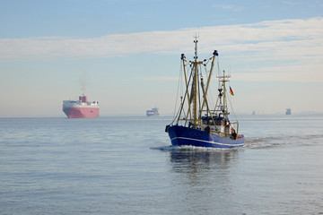 Naklejka premium Fischkutter und Frachter vor Cuxhaven