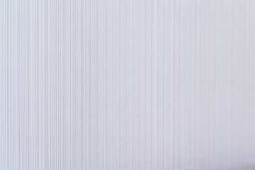 High resolution full frame background of pale and beige colored striped wallpaper. Selective focus, shallow depth of field.