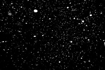 Obraz premium falling snow on a black background, snowfall at night, white spots on a black background