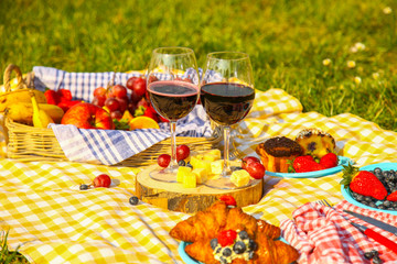 Picnic at the park on the grass: tablecloth, basket, healthy food and accessories