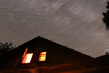 Star trail sky with a cottage