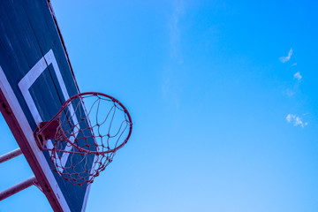 Basketball hoop on blue sky background.