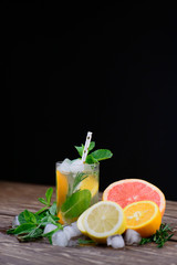  Lemonade with ice, grapefruit and rosemary on a wooden table. Cold drinks.