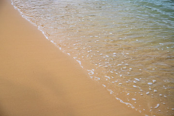 Sea water tide over yellow sand beach. Tropical seaside concept photo. Clear water on sand beach.