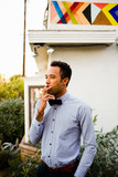 Thoughtful young man smoking cigarette while standing in backyard during party