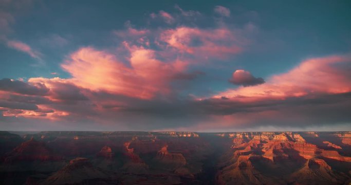 Gorgeous time-lapse of clouds racing over a Grand Canyon vista at sunset with beautiful lighting, clouds, red cliffs and blue skies in 4K DCI.