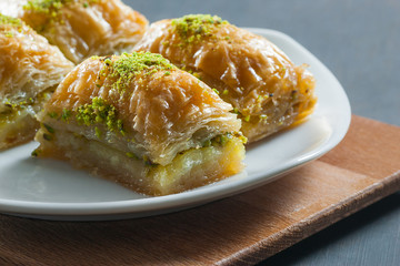 Traditional turkish dessert antep baklava with pistachio on white plate. Desserts concept