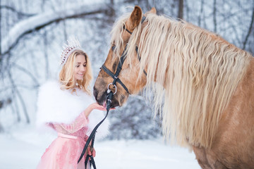 Princess in crown feeding horse in winter. Fairy tale © Elina Leonova