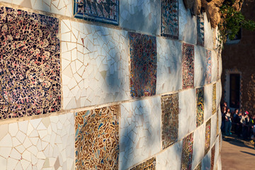 Trencadis technique decorative square ceramics on a wall in the Guell park