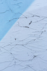 The texture of cracked banner fabric. Old textile surface painted in two colors. The image is divided into blue and white areas diagonally. Perfect for background and design.