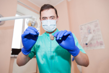 Fototapeta na wymiar Portrait of a male dentist with tools in hands