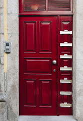 Letterboxes on red wooden door