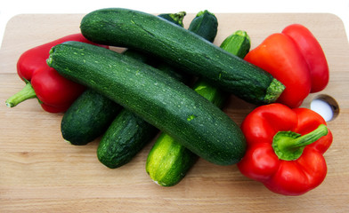 Vegetables on wooden table, zucchini and pepperoni, white background