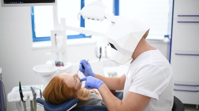 Doctor dentist in polygonal panda mask make oral hygiene dental treatment surgery in dental cabinet. Funny video