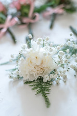 white roses buttonhole corsage displayed before the wedding