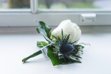 white roses buttonhole corsage displayed before the wedding