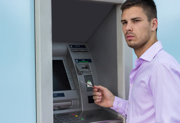 Young businessman withdrawing money from a cash machine