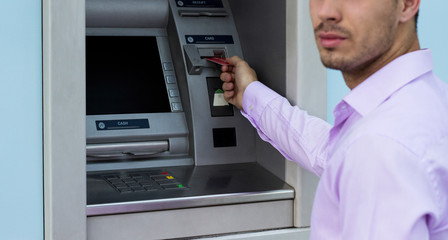 Young businessman withdrawing money from a cash machine