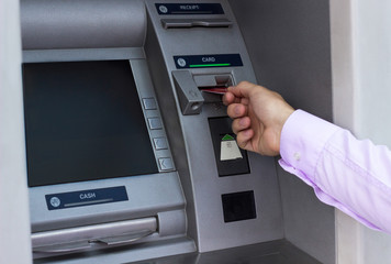 Young businessman withdrawing money from a cash machine