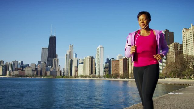 Ethnic African American female in the city doing a running workout with ear buds