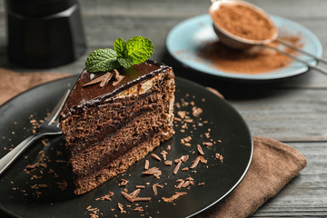 Plate with slice of chocolate cake and fork on table