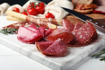 Cutting board with different sliced meat products served on table