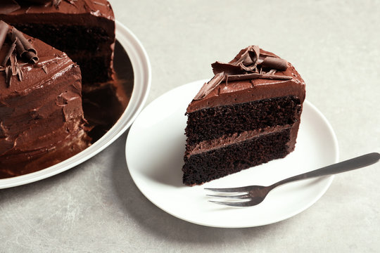 Plate with slice of tasty chocolate cake and fork on table