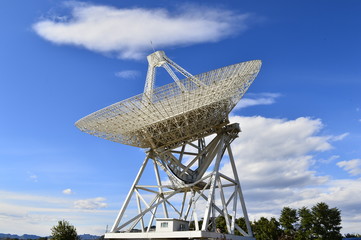 Array of satellite dishes or radio antennas against sky. Space observatory.