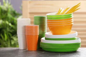 Tuinposter New plastic dishware on table against blurred background. Table setting © New Africa