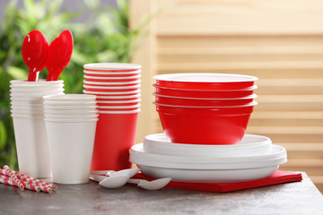 New plastic dishware on table against blurred background. Table setting © New Africa