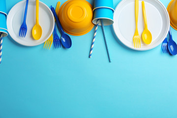 New plastic dishware and space for text on color background. Table setting