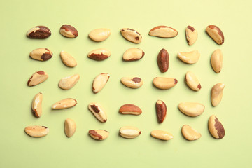 Flat lay composition with Brazil nuts on color background
