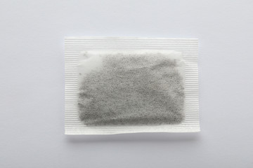 Fototapeta na wymiar Unused tea bag on white background, top view