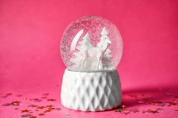 Snow globe with deer and trees on color background