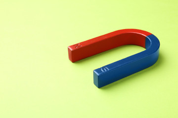 Red and blue horseshoe magnet on color background. Space for text