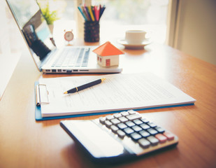 A scale house on some forms for a deed to conceptualize on the financial investment.