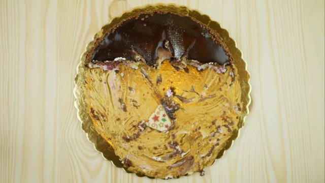 Chokolate cake eaten by itself. Sloppy bites, stop motion. View from above. Reverse playback.