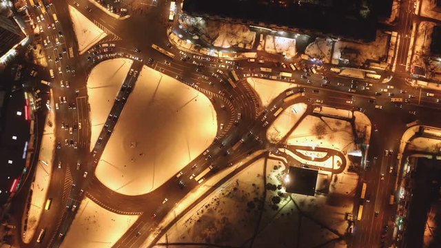 Night Highway city Traffic crossroad from above shot with Drone. Buses and cars passing by a circle fork with lots of city lights on the roads.