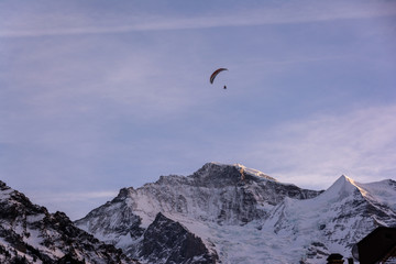 Fototapeta na wymiar Ski paragliding over the mountains of Jungfrau region in Switzerland