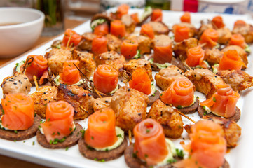 Red salmon appetizers on bread slices