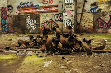 Twistel rusty metal band on the floor in abandoned industrial place